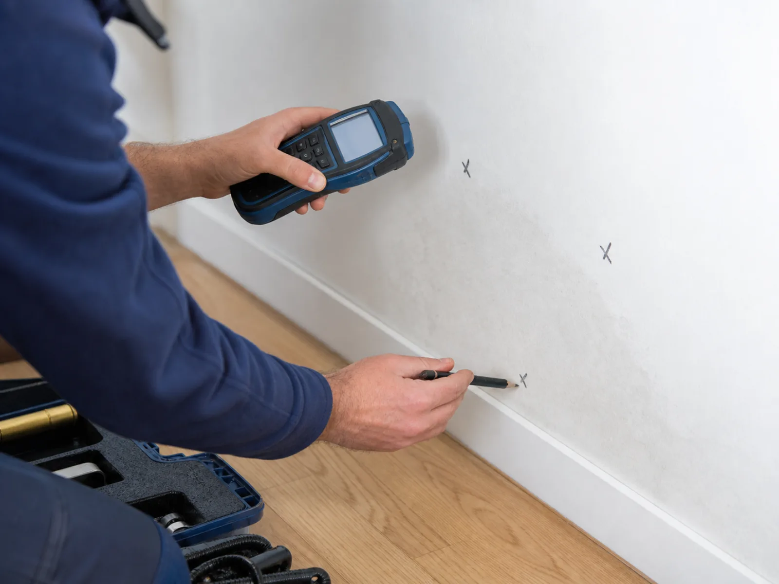Feuchtemessung an Sockelleiste und Wand in einer Wohnung